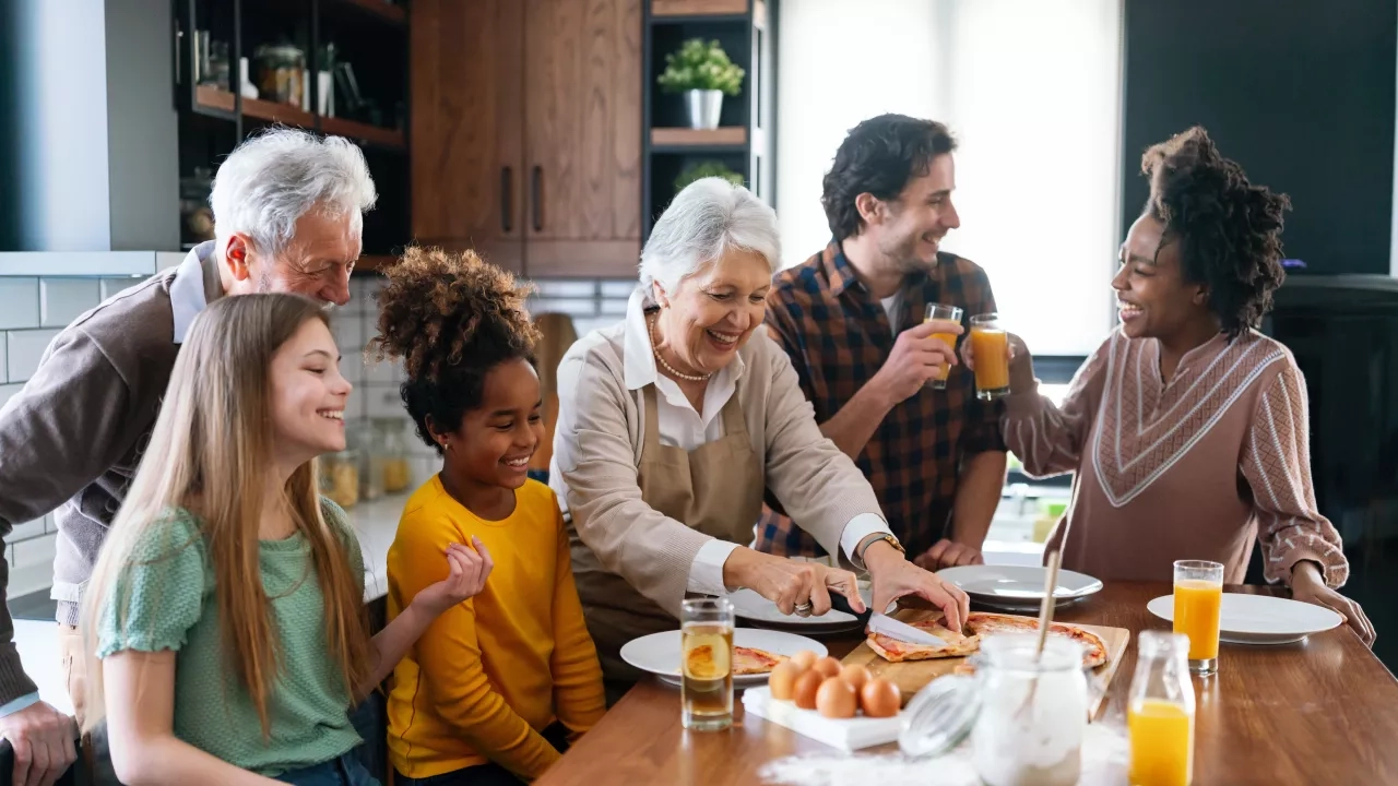 Multi generational family eating pizza in kitchen