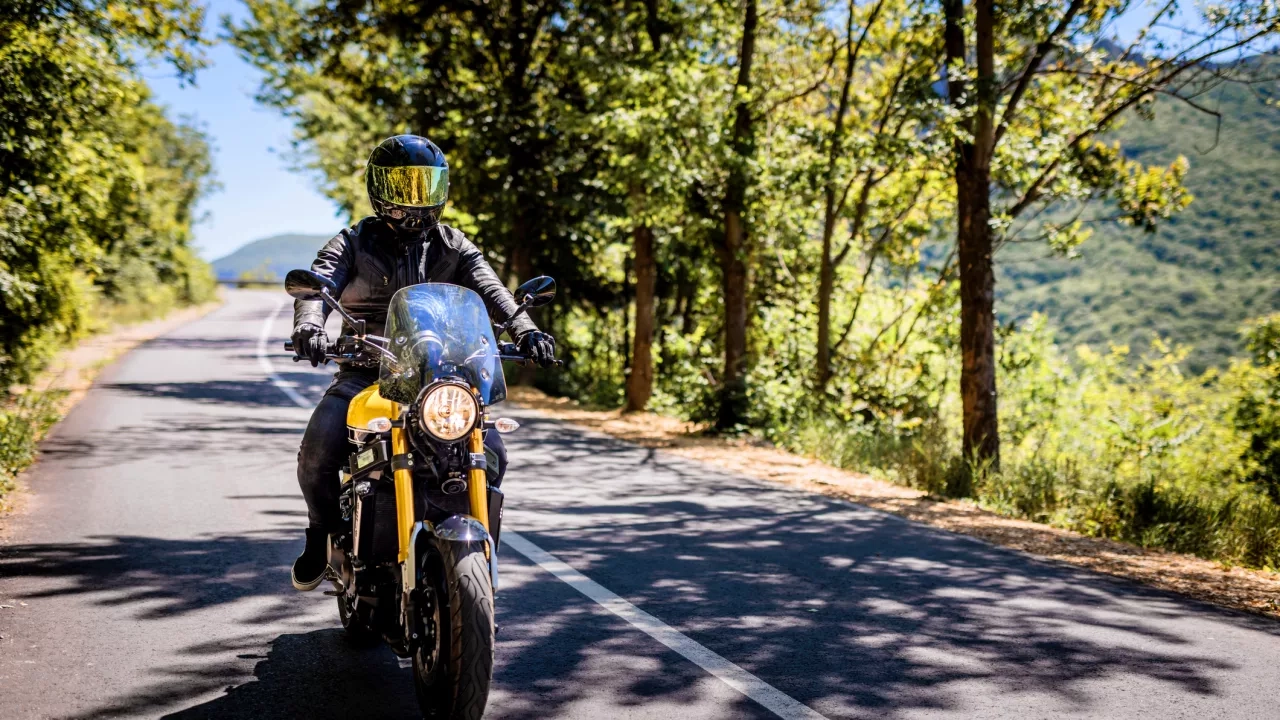 Biker with full safety gear enjoys ride on country road