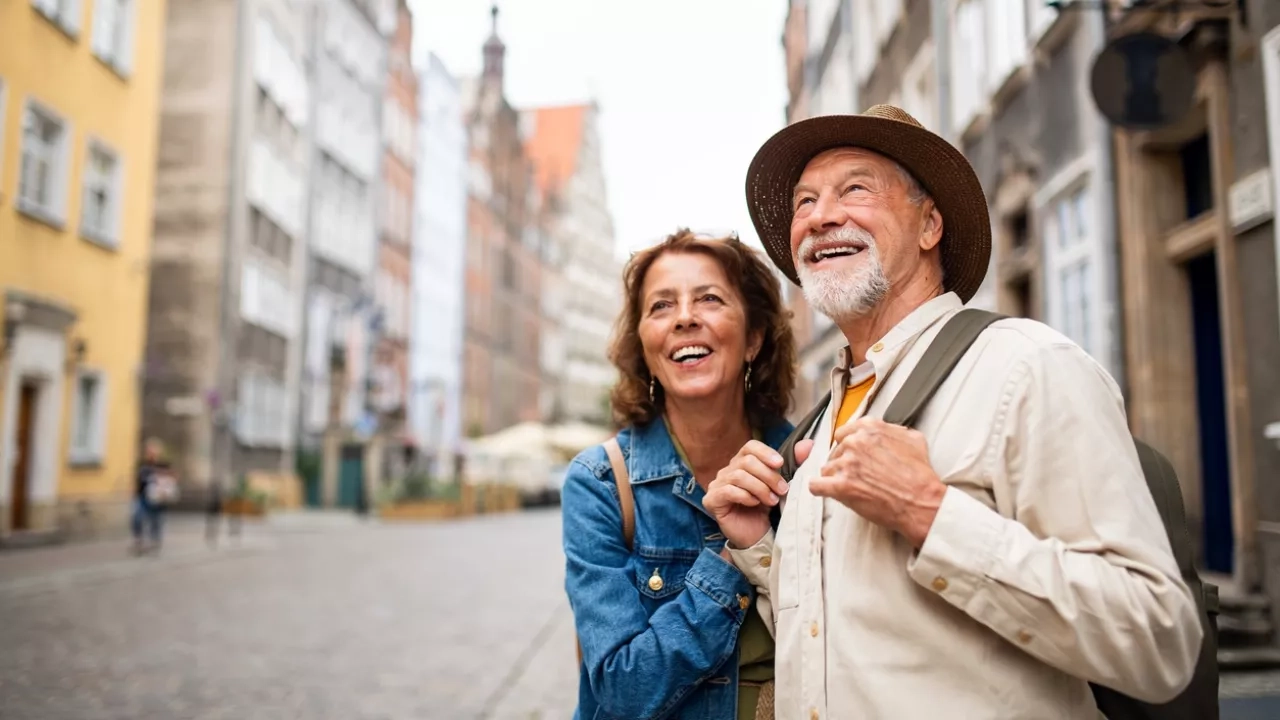 happy senior couple tourists outdoors in historic town