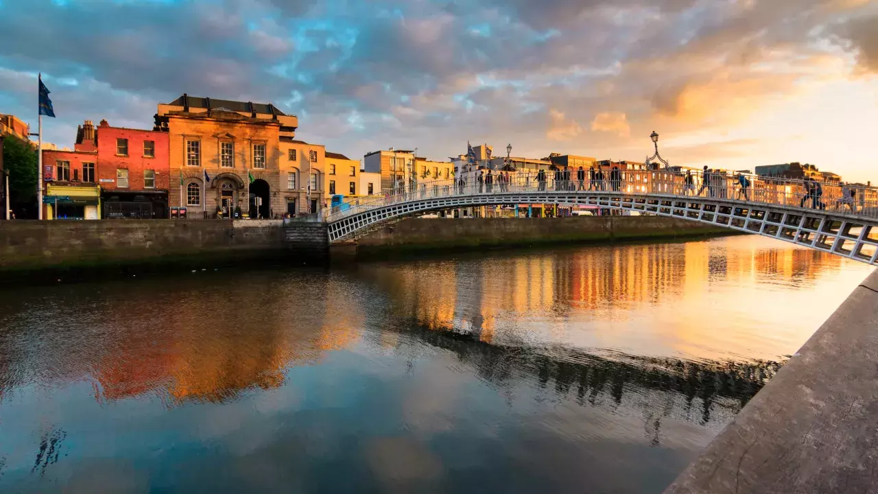 A bridge shadowing over a canal in Europe during sunset