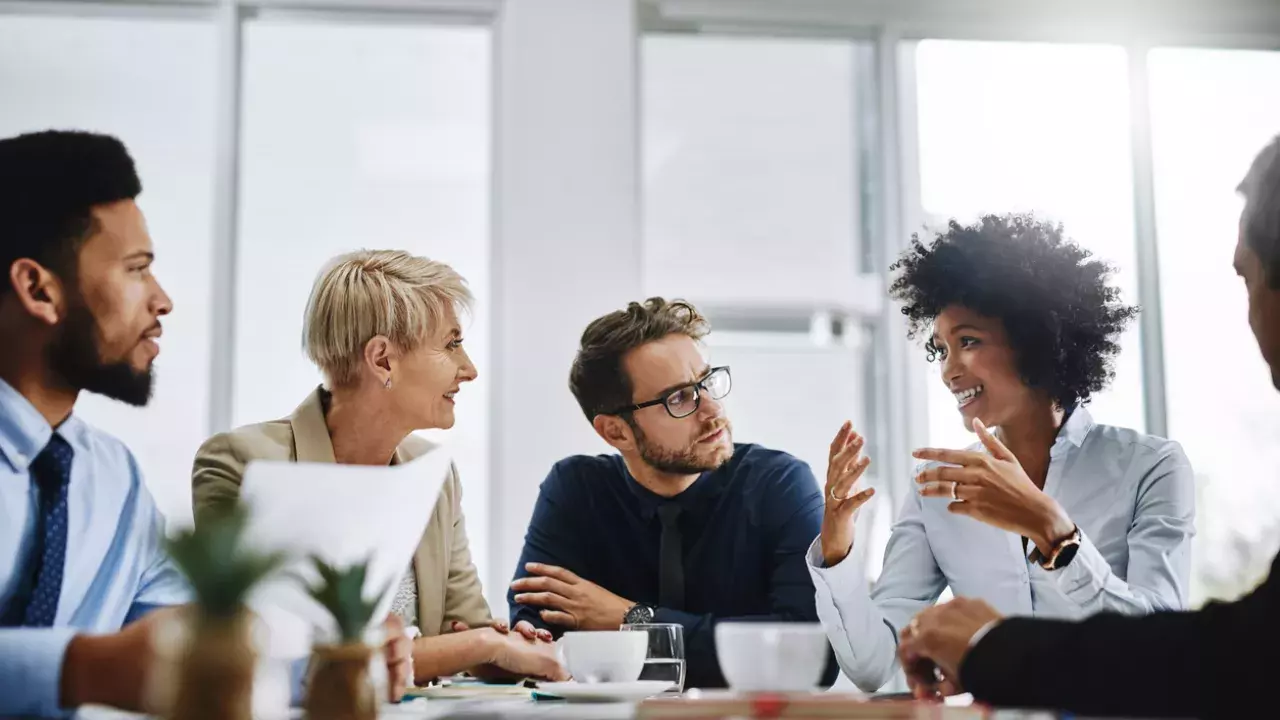 group of 5 diverse business people in a meeting with coffee cups