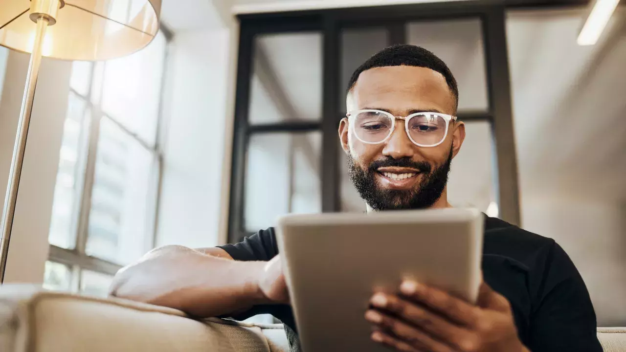 man on his tablet smiling at home