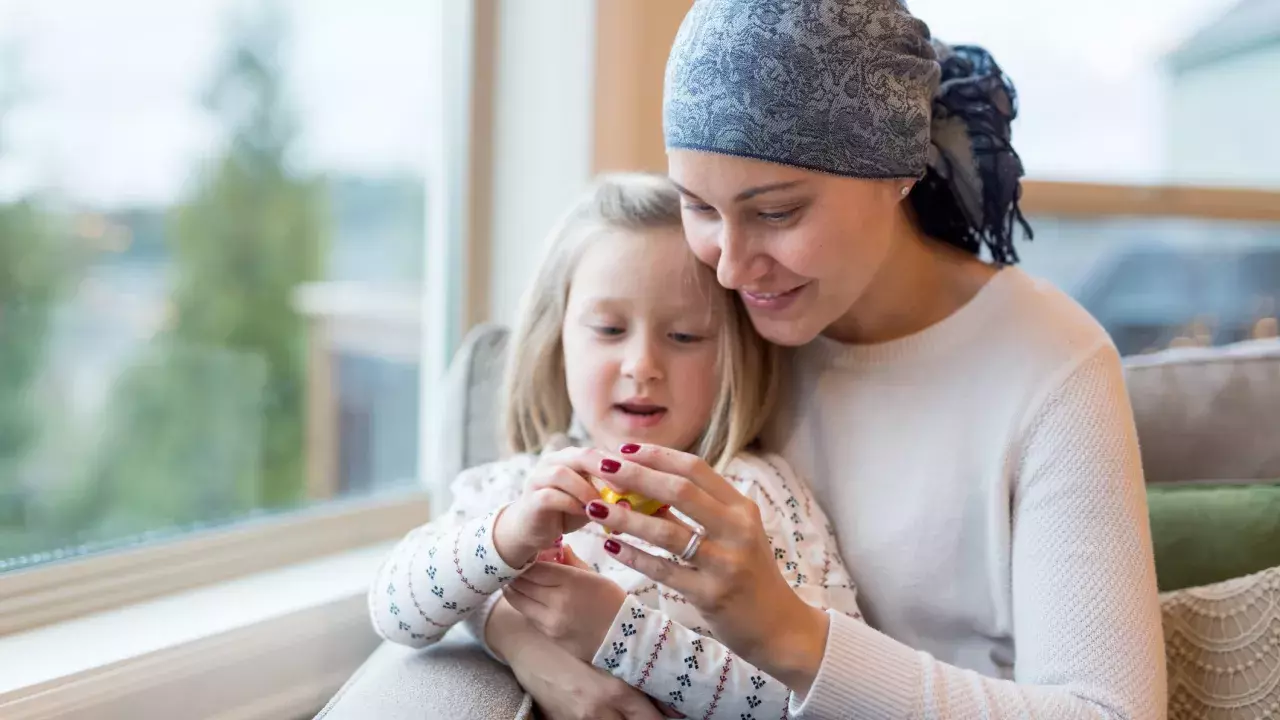 Mother with a critical illness sitting in front of a window with daughter