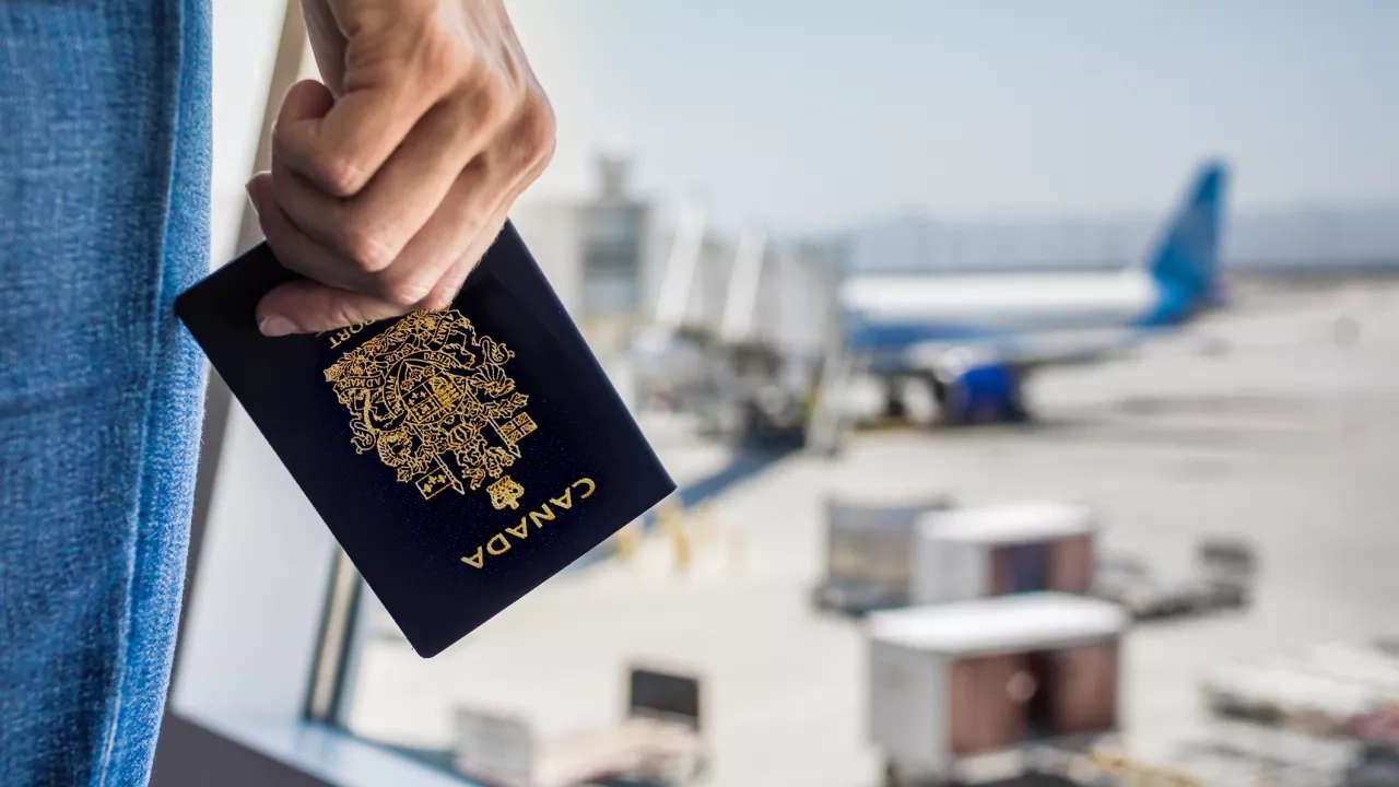 Person holding a Canadian passport at the airport