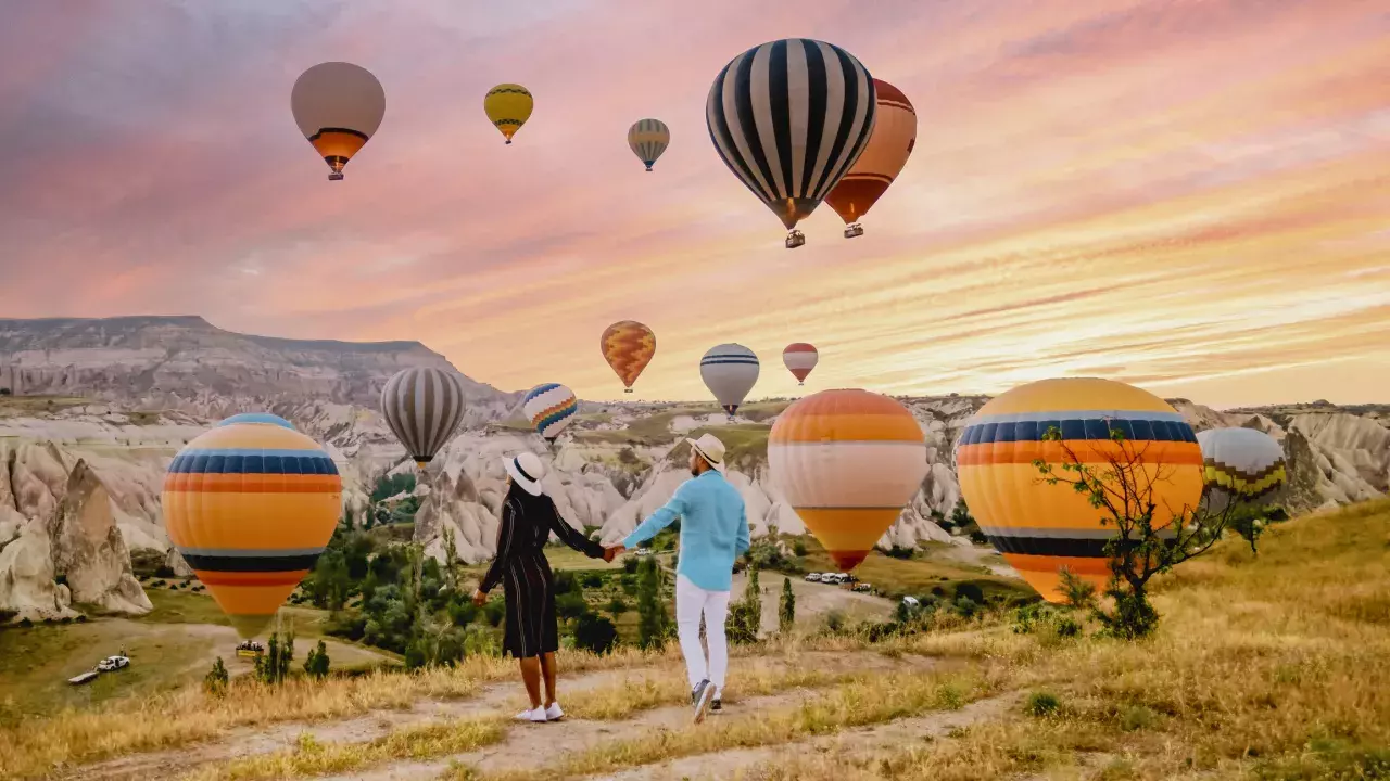 A couple watching the hot air balloons in Cappadocia, Turkey during sunrise