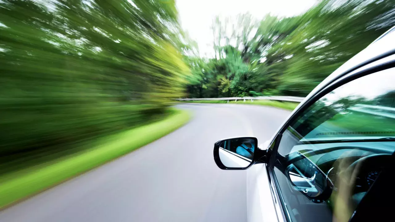 car driving on road showing rear view mirror