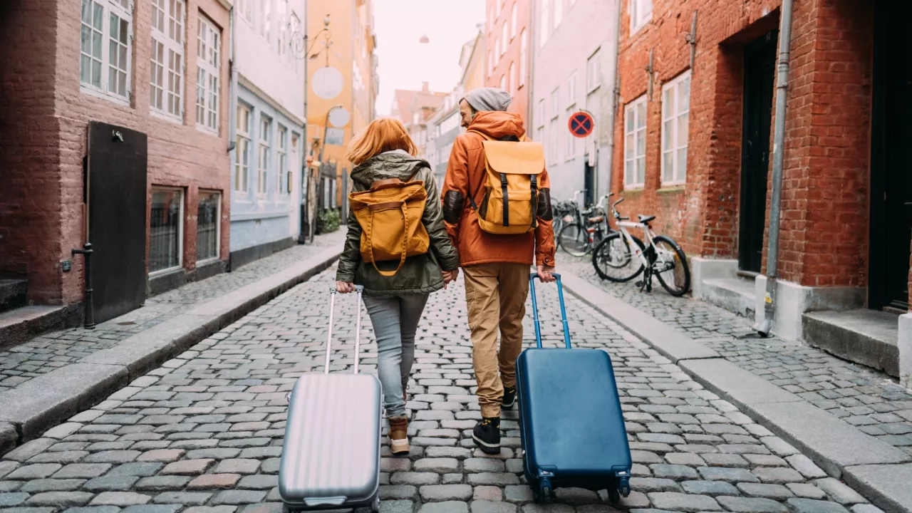 couple walking down the street and pulling the suitcases
