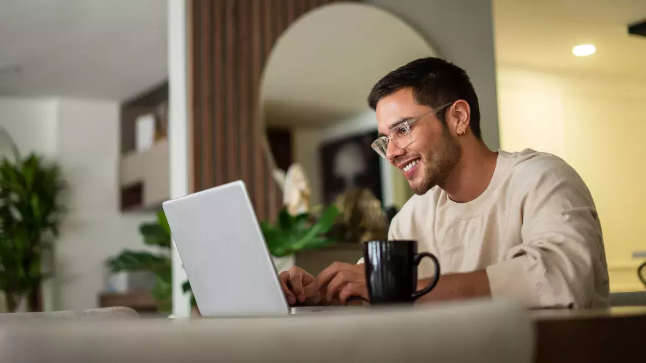 Man looking at computer with coffee