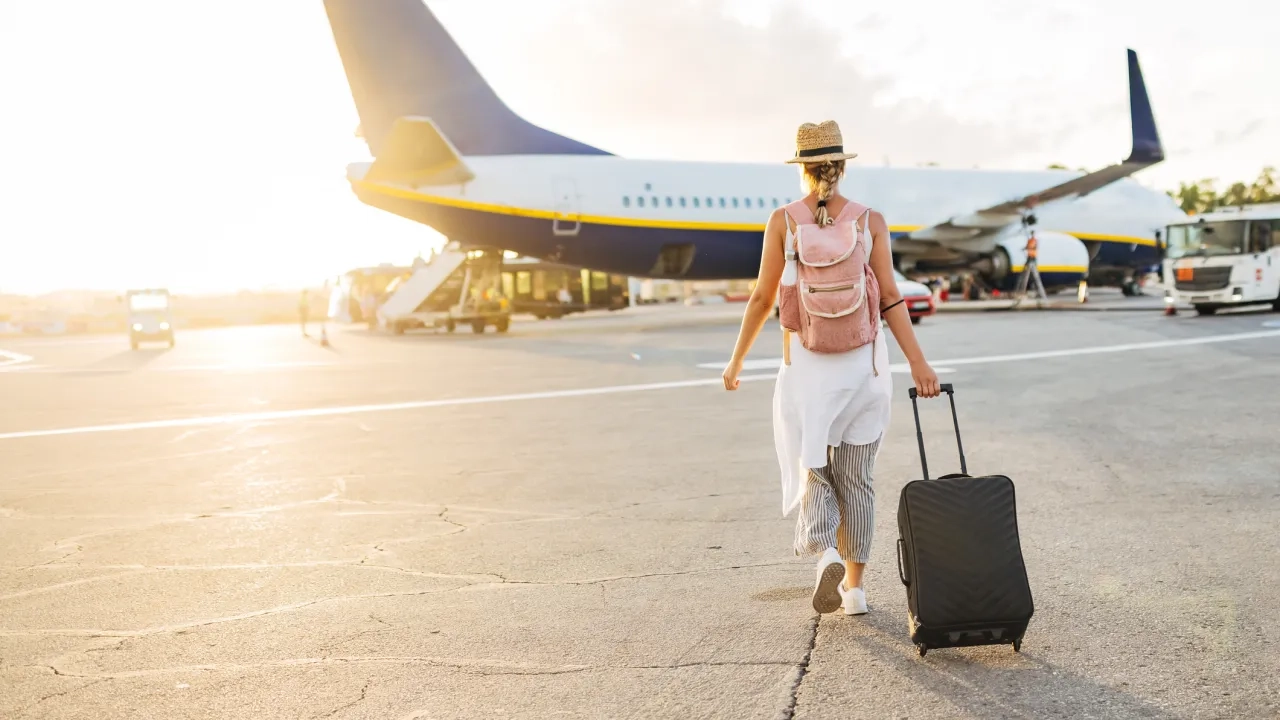 traveler on airport tarmac boarding plane