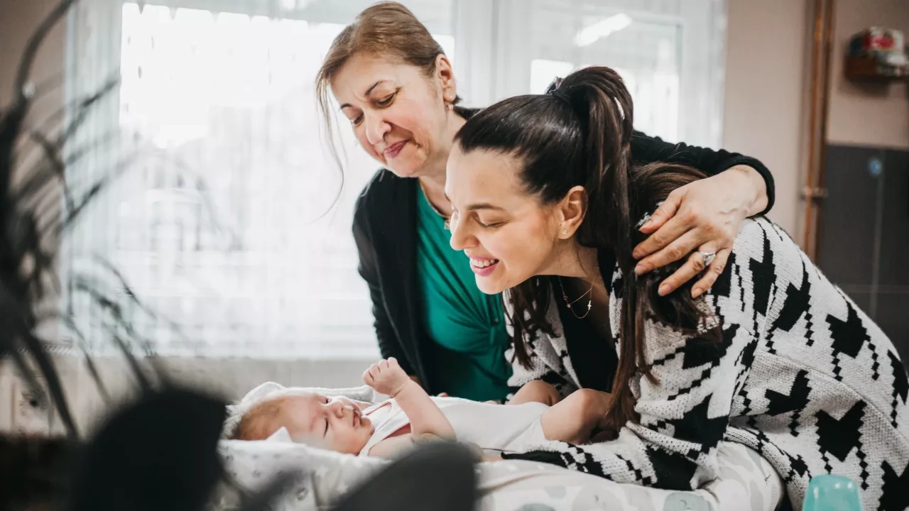 Mother and grandmother tending to baby at home