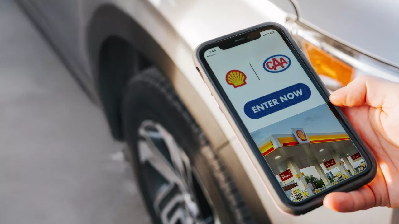 Hand holds mobile phone with Shell App contest screen