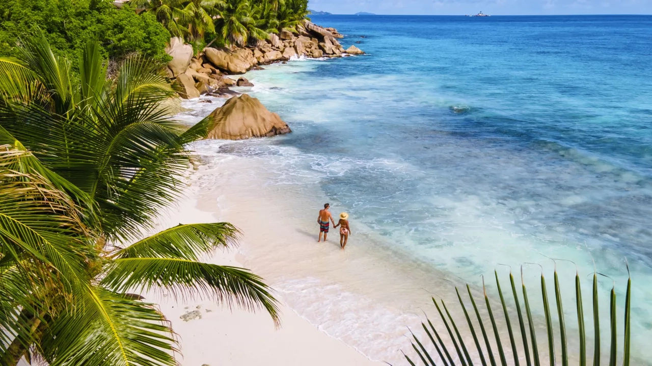 Aerial shot of a couple on a white sandy beach in Seychelles