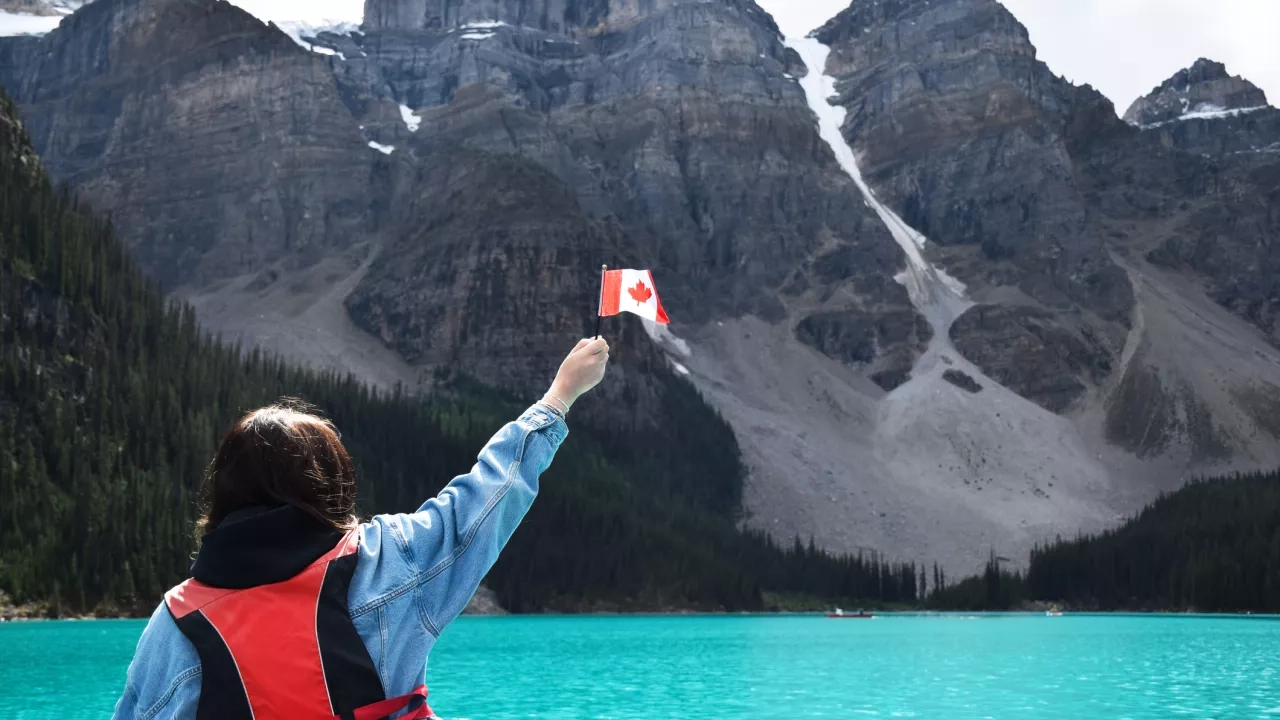 Woman holding a Canada flag on a trip in Canada