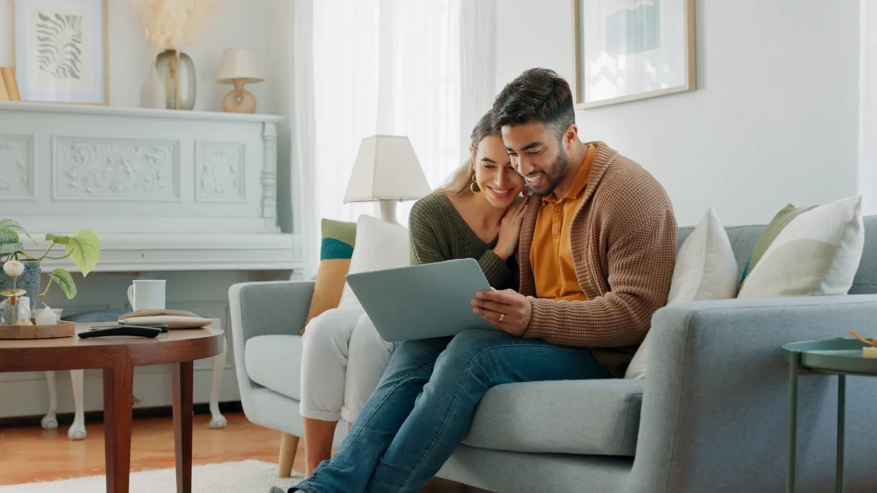 A young couple on couch using a laptop