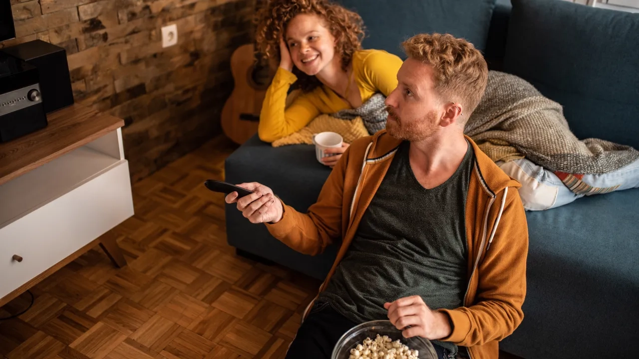 A man and woman watching tv together