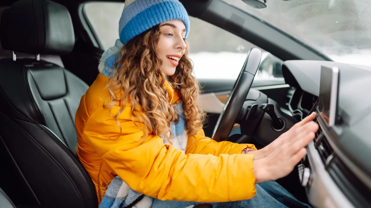 Woman warming herself in her car