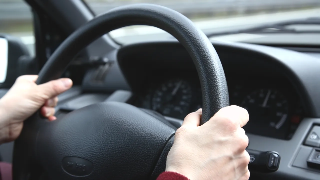 Hands on the steering wheel of a car