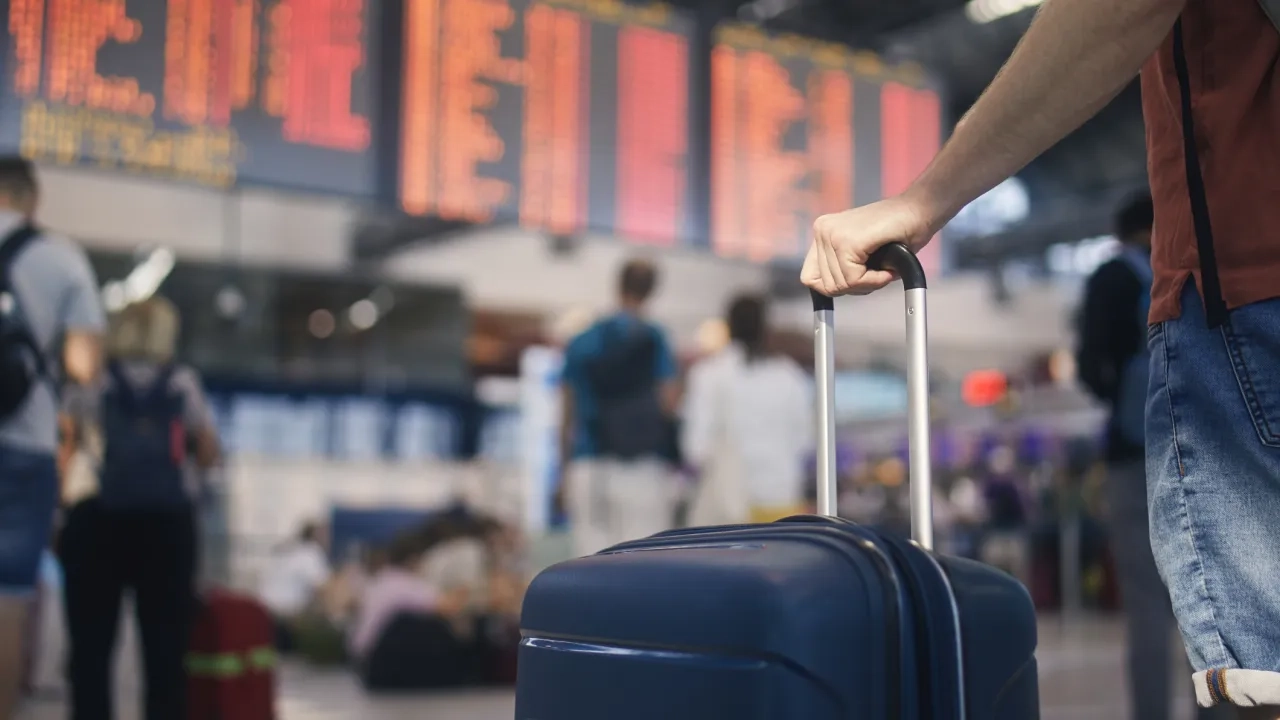Man holding suitcase at airport