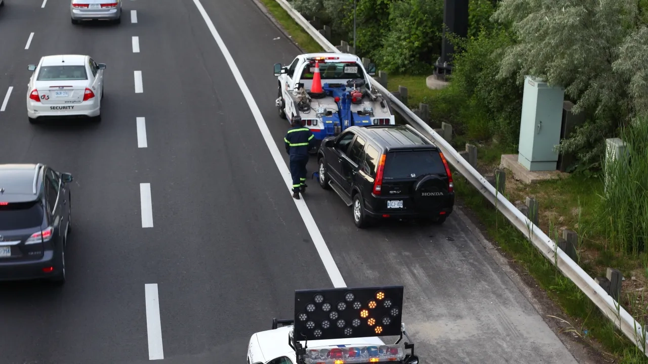 Tow truck driver on the side of the road.