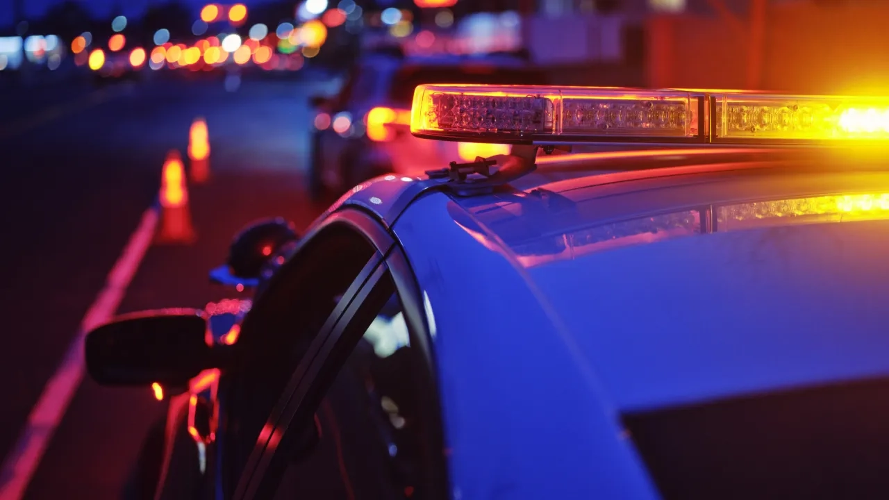 Police car at night with lights flashing.