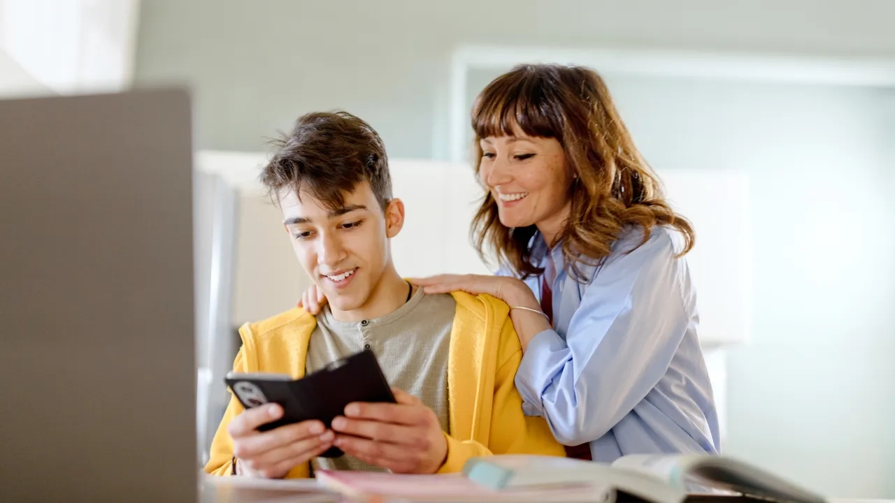 A mother and son looking at a phone