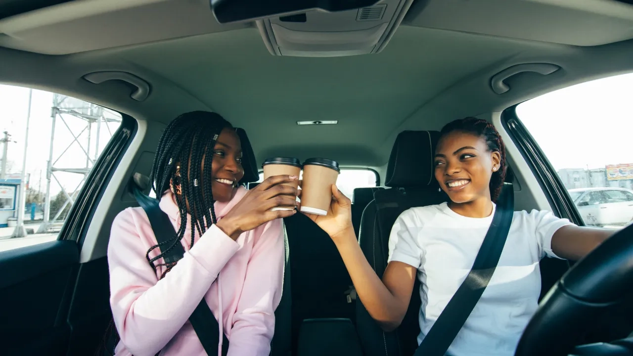 two women cheer over coffees