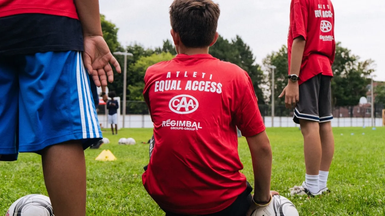 Youth soccer players kneeling while listening to a coach