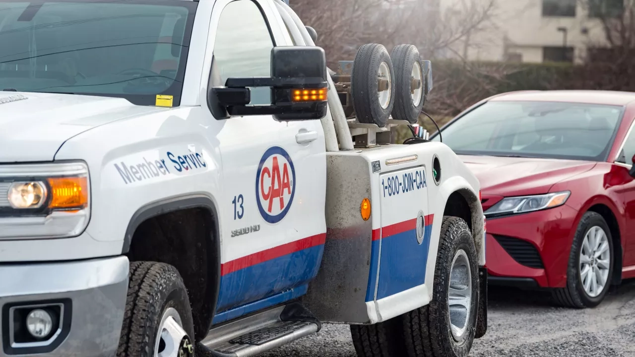 A CAA tow truck providing roadside assistance to a red car. CAA leaves your manufacturers roadside assistance plan in the dust (including kia roadside assistance, mazda roadside assistance, nissan roadside assistance