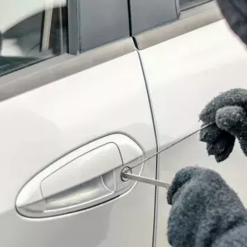 Car thief picking lock