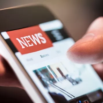 Person reading news on cell phone