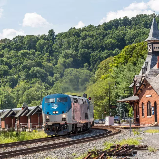 Amtrak Vacations train in USA riding along a building