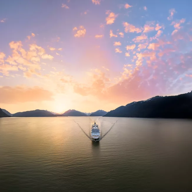 Holland America Line's Nieuw Amsterdam ship sailing through the sunset