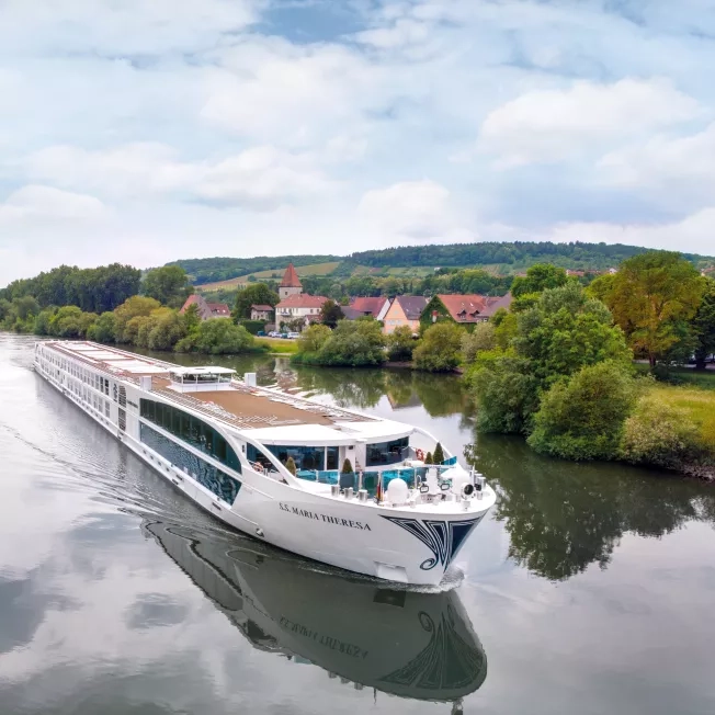 Exterior shot of a Uniworld Boutique River Cruises' ship going down a canal.