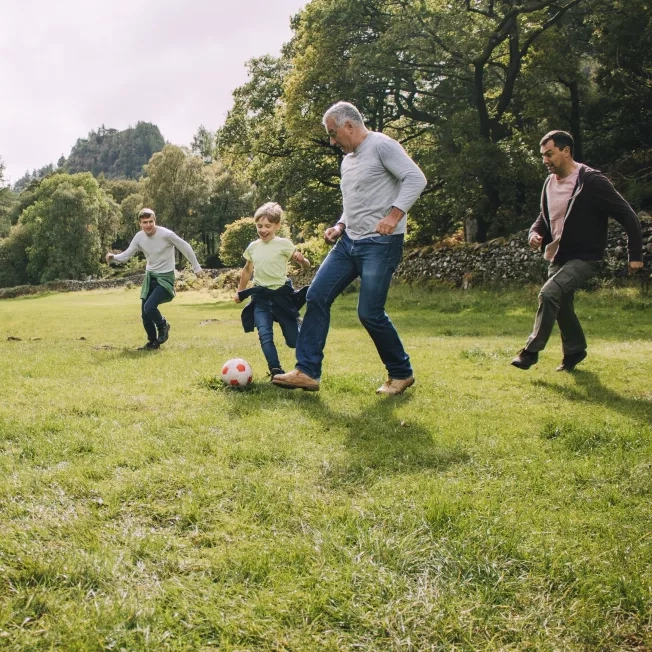 Grandpa dad and grandsons playing outdoor sports