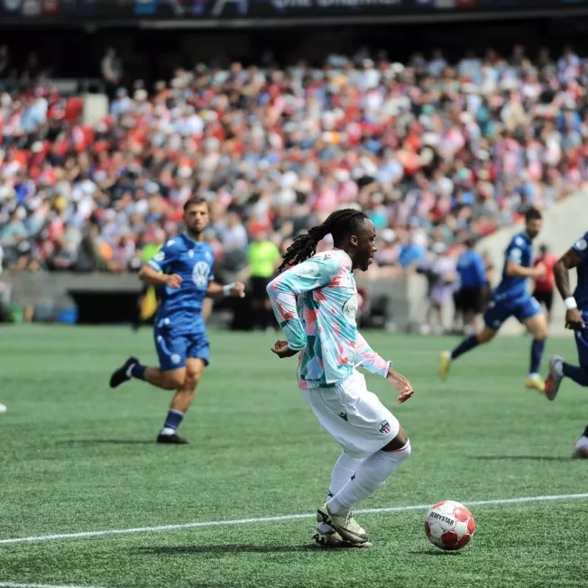 Atlético Ottawa player advances the ball down the pitch