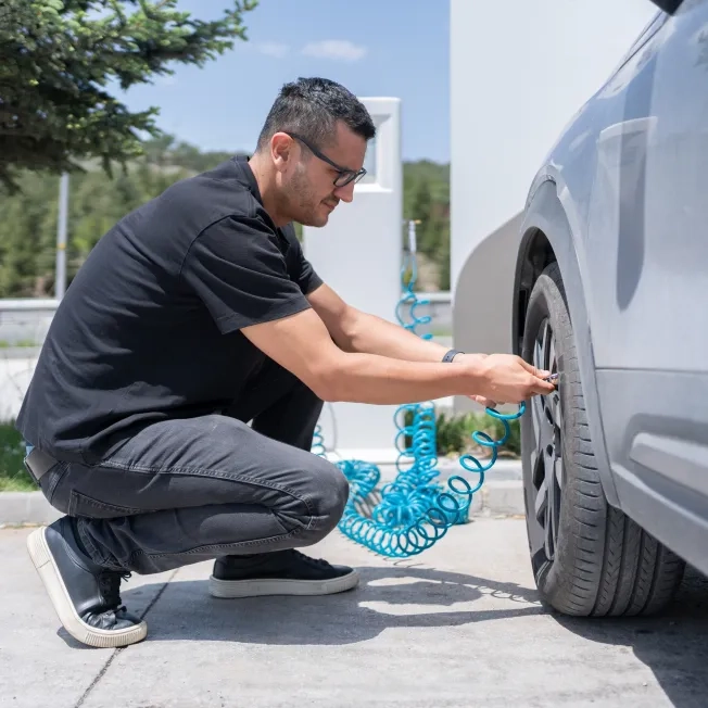 Man Checking Air Pressure In The Car Wheel