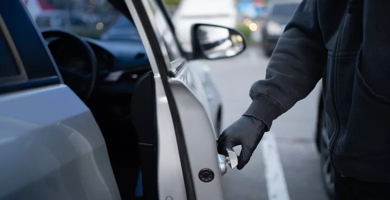 Close-up shot of a thief wearing a black shirt and black gloves. 