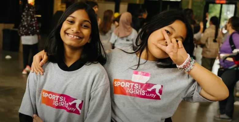two young girls smile at the camera wearing sports day the girls way tshirts