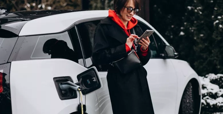 Woman charging ev and talking on the phone