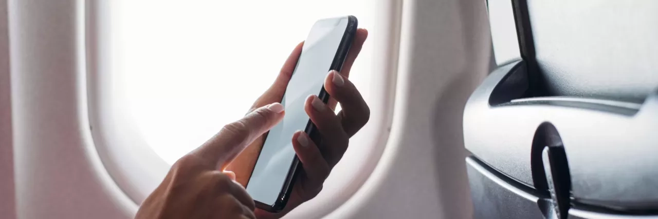 user using mobile phone on plane