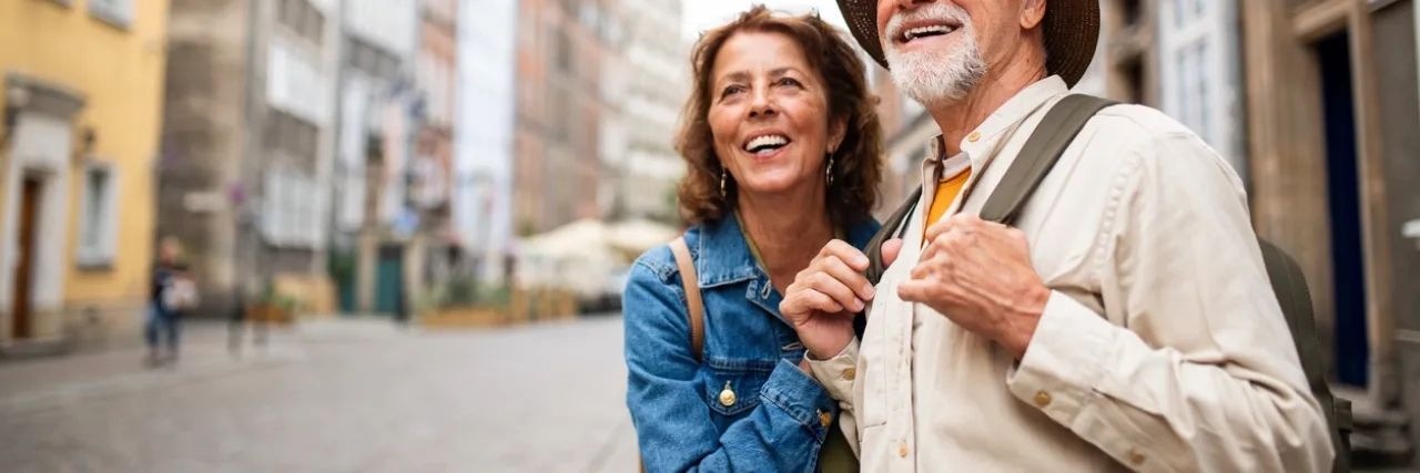 happy senior couple tourists outdoors in historic town