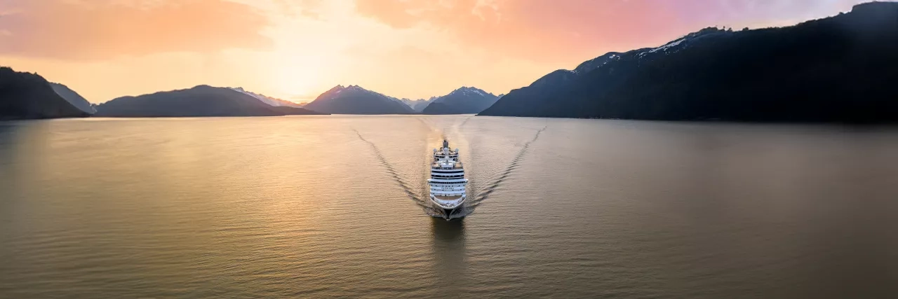 Holland America Line's Nieuw Amsterdam ship sailing through the sunset