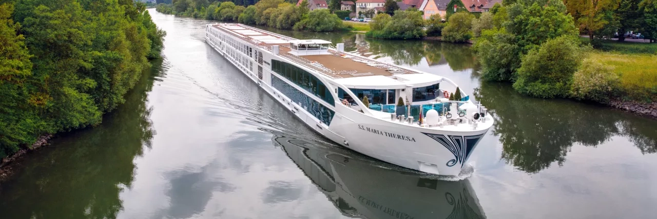 Exterior shot of a Uniworld Boutique River Cruises' ship going down a canal.