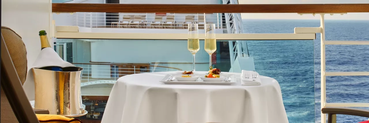 A lovely table setup on a balcony in a stateroom onboard a Seabourn Cruise.