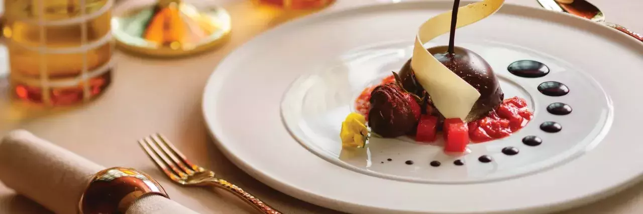 A well-plated dessert plate with a glass of wine onboard Silversea Cruises.