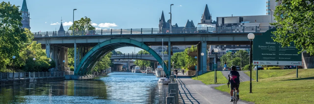 Cyclist cycling downtown Ottawa along the Rideau Canal