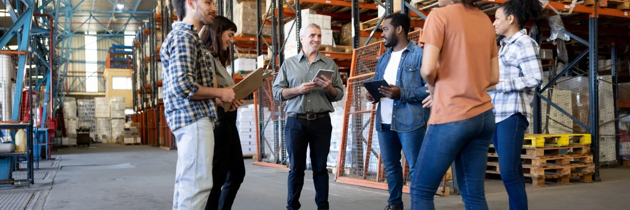 Business manager talking to a group of workers at a distribution warehouse