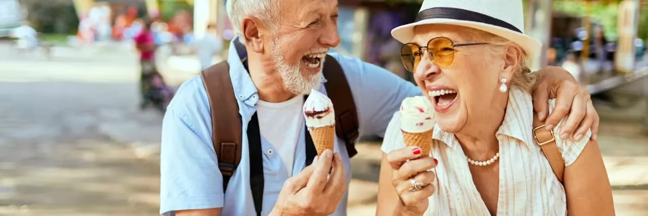 Older couple laughing while eating ice cream