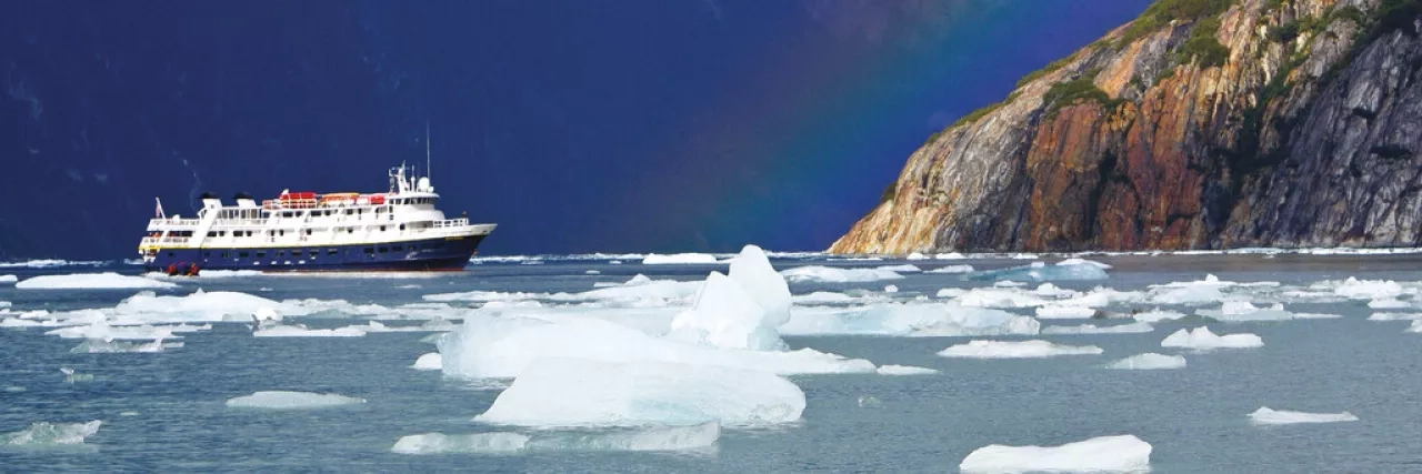 National Geographic Lindblad Expeditions ship near a rainbow in Alaska