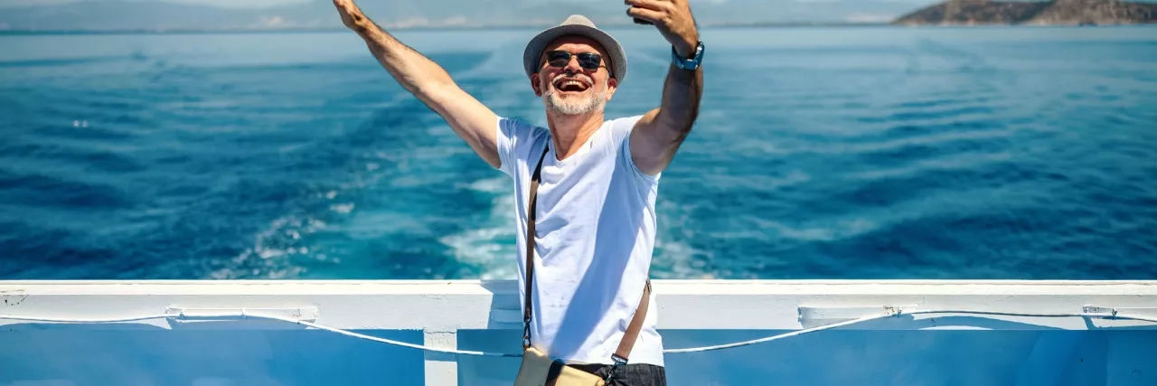 Happy senior man taking a selfie on a cruise.